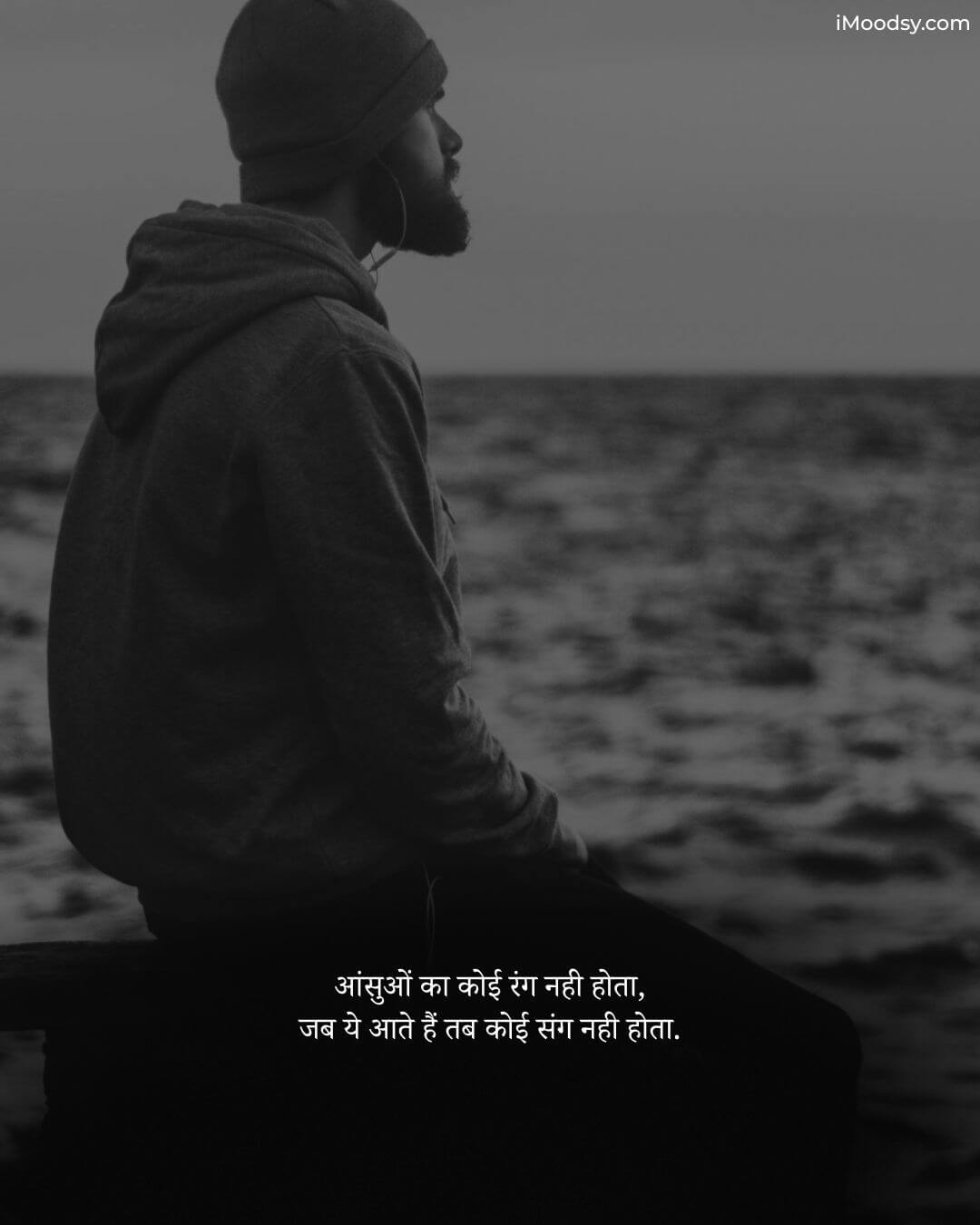 सैड स्टेटस हिंदी में (Sad Status in Hindi) with a black and white image of a man sitting by the sea.