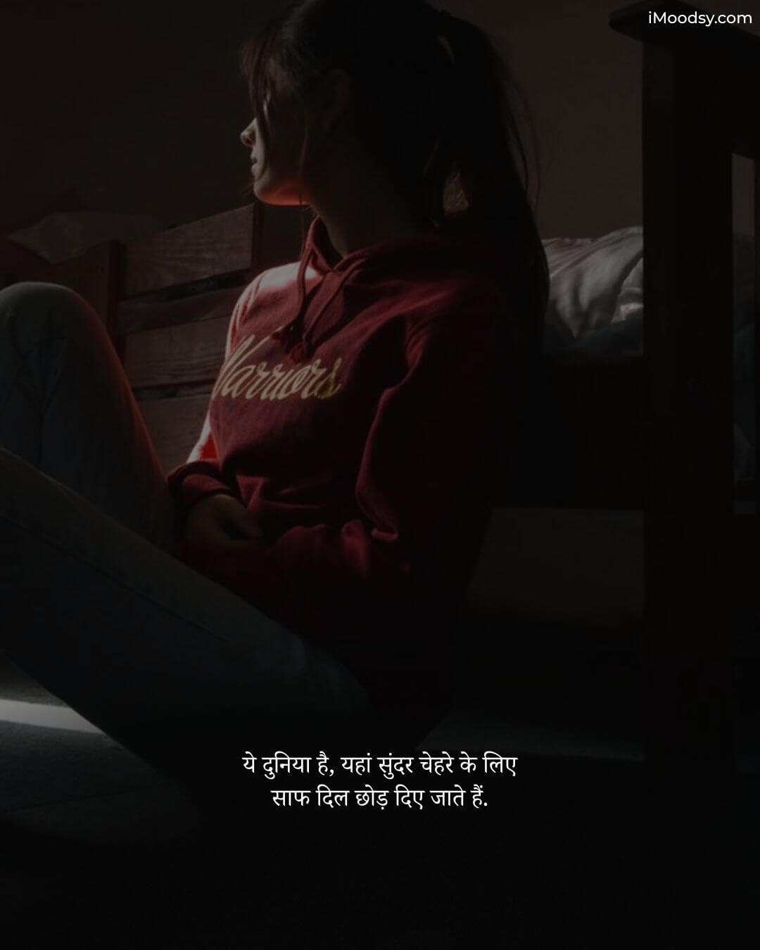 Hindi Sad Status Text featuring a girl in a red hoodie sitting in a dark room, reflecting on the world.